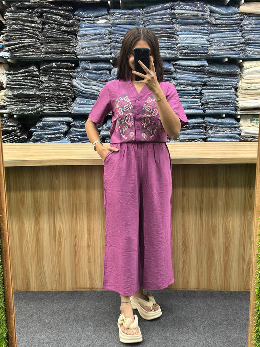 Woman wearing a purple embroidered two-piece outfit with wide-leg pants and short sleeves by Vinayak Fashion