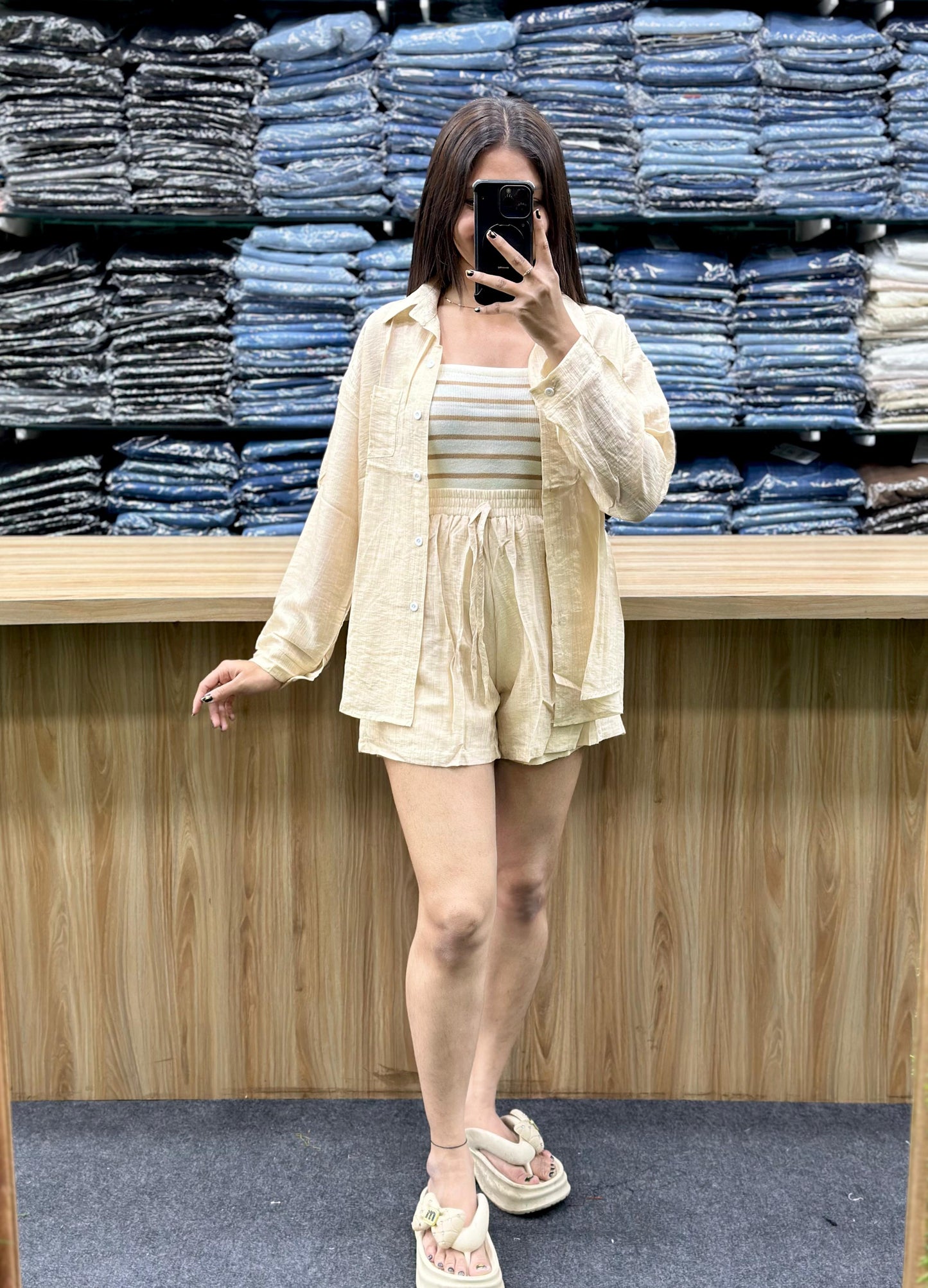 Woman wearing summer casual cotton outfits beige shirt and shorts set with striped top barefoot indoors