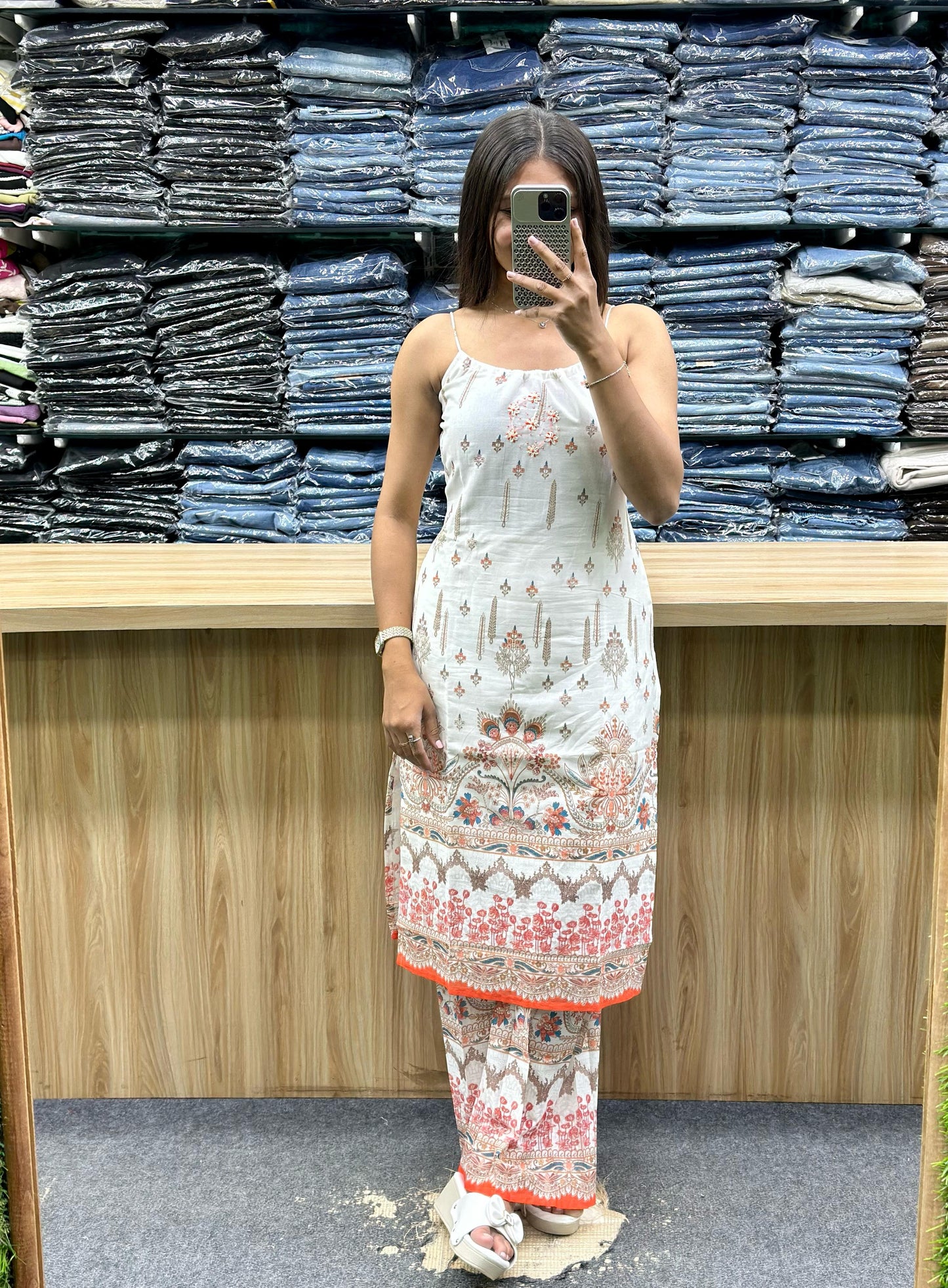 Woman wearing a white and coral printed sleeveless ethnic kurta with matching pants from Vinayak Fashion