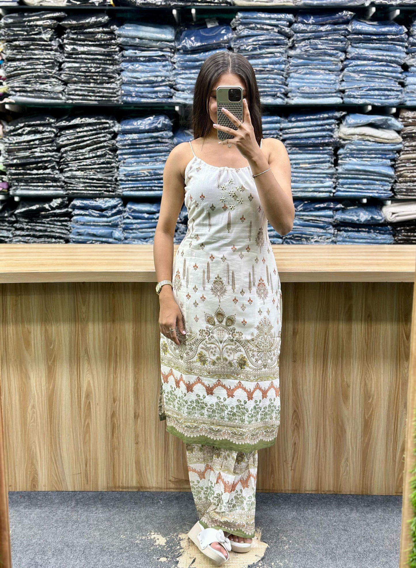 Woman wearing white embroidered sleeveless kurta and matching pants set from Vinayak Fashion