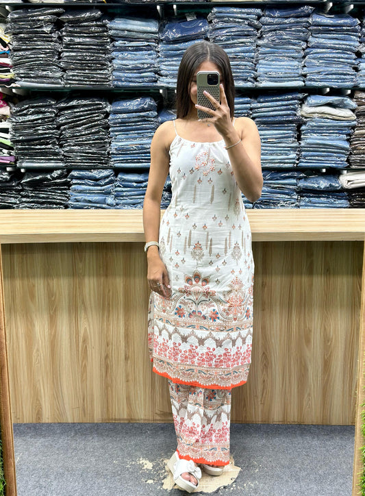 Woman wearing a white and coral printed sleeveless ethnic kurta with matching pants from Vinayak Fashion