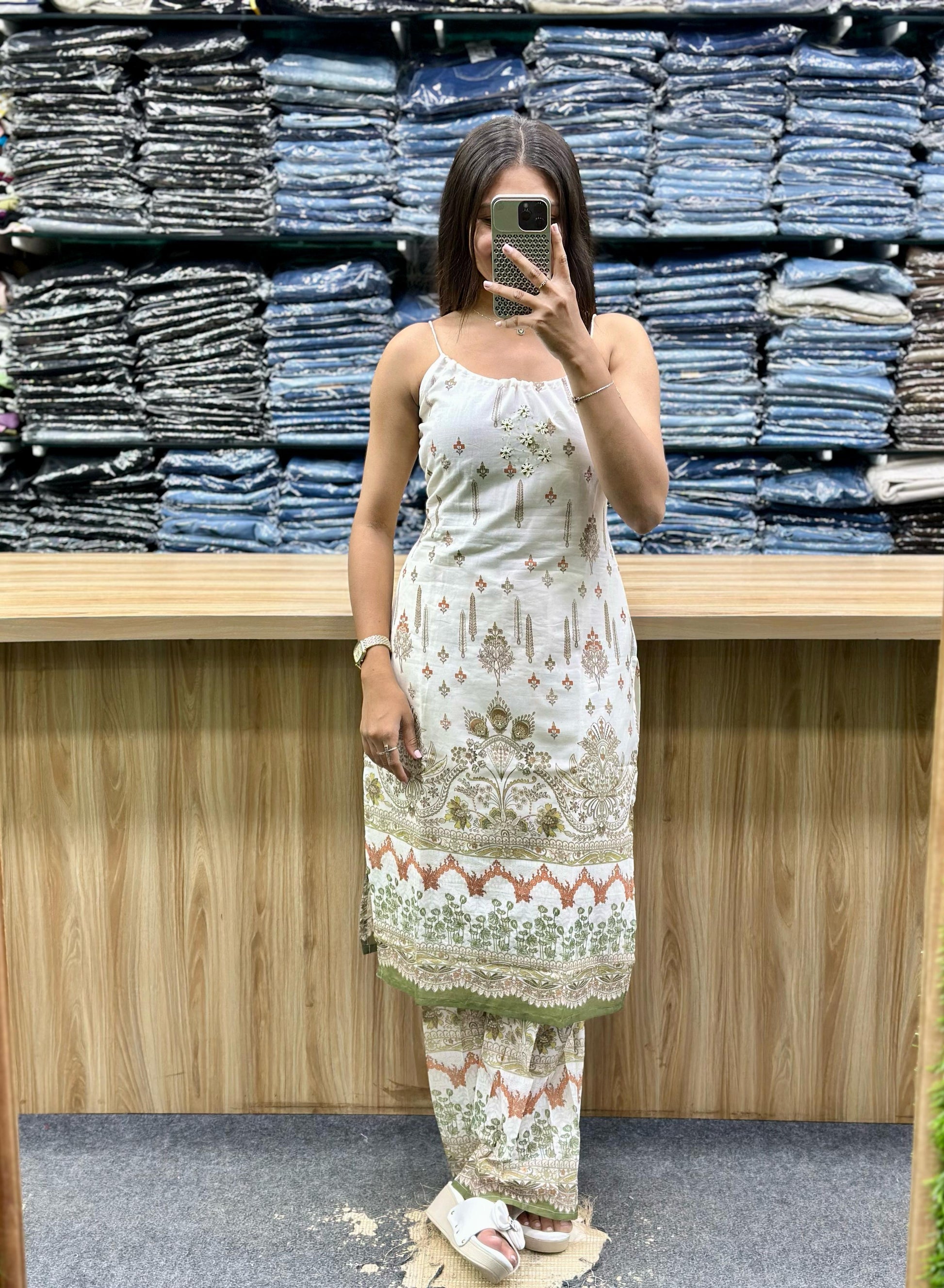 Woman wearing white embroidered sleeveless kurta and matching pants set from Vinayak Fashion