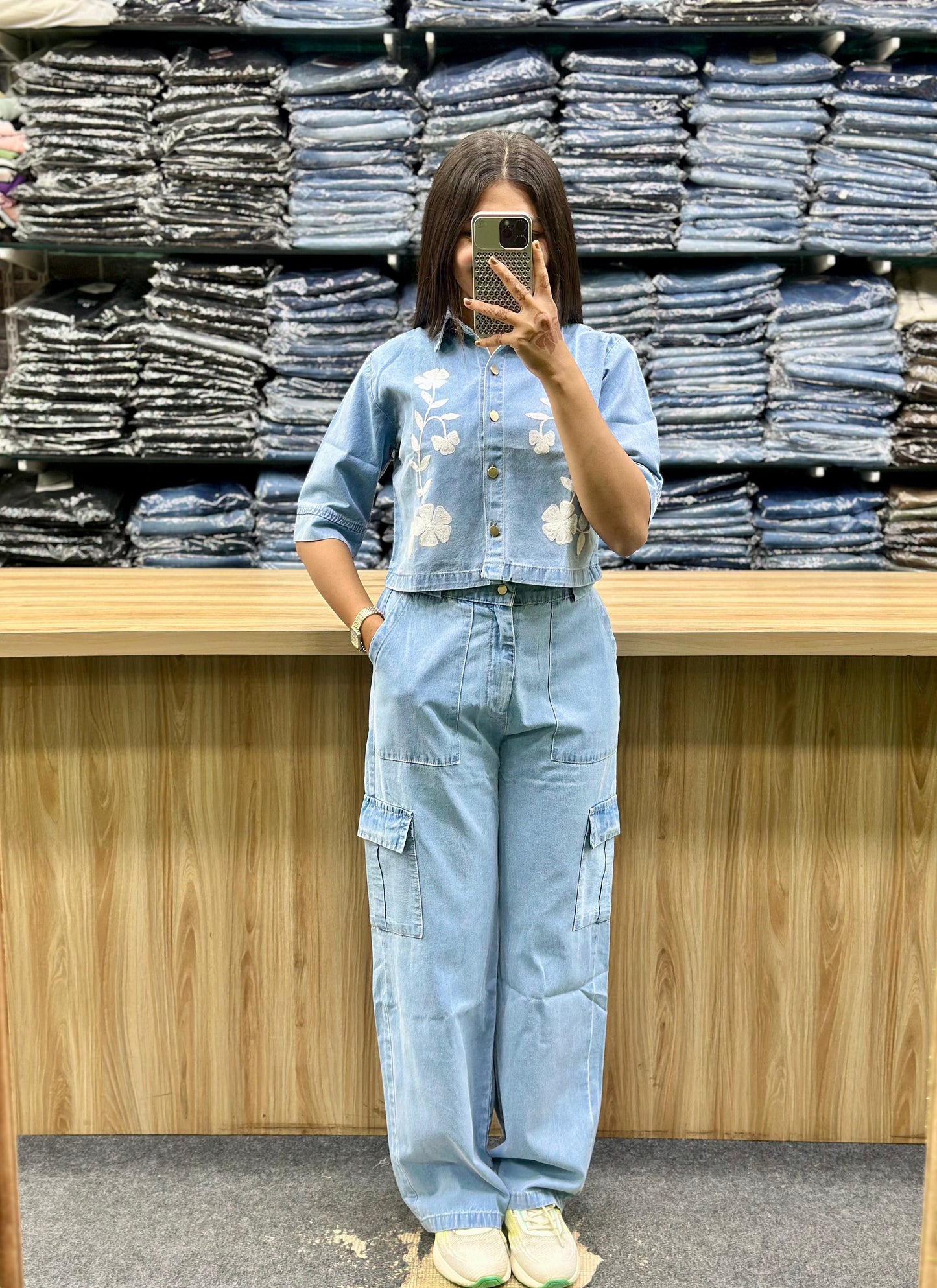 Woman wearing blue women's denim cord set with floral embroidery and cargo pants in a clothing store